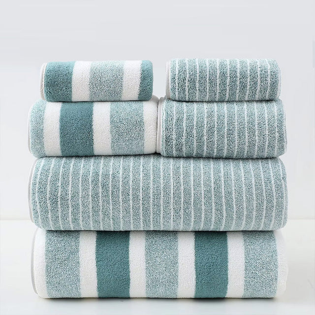 Stack of striped towels in teal and white on a light gray background