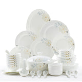 Set of white ceramic dinnerware with floral patterns on a white background