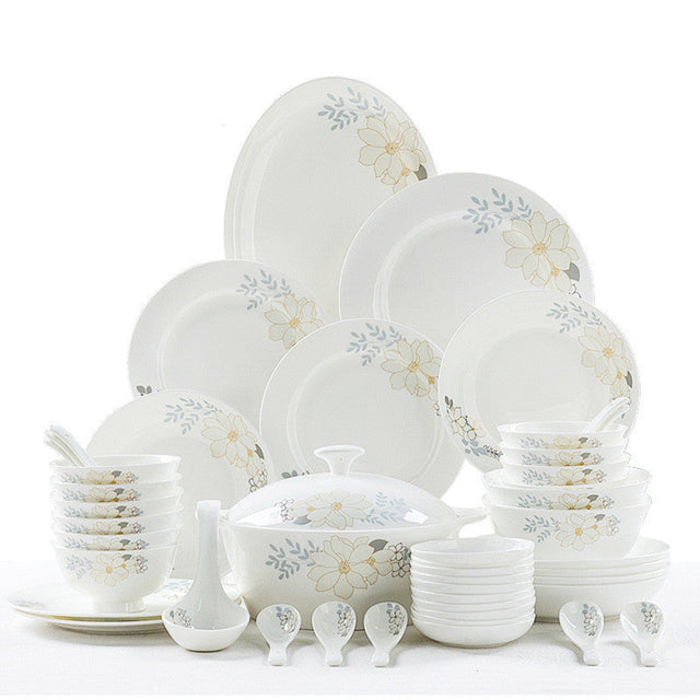 Set of white ceramic dinnerware with floral patterns on a white background