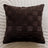 Brown woven pillow on a textured beige background