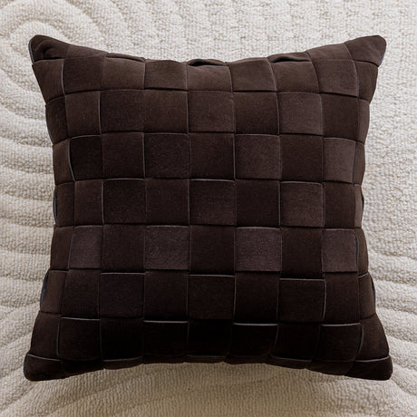 Brown woven pillow on a textured beige background