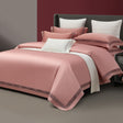 Pink bedding set on a bed with a neutral background