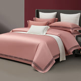 Pink bedding set on a bed with a neutral background