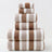 Stack of brown and white striped towels on a light gray background