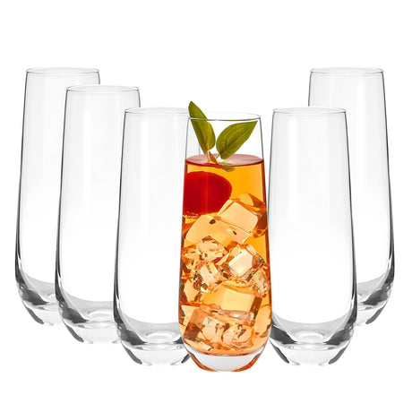 Set of clear stemless glasses with a drink containing ice cubes and a leaf on a white background