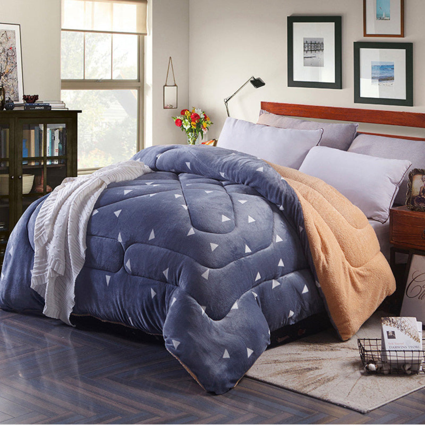 Blue comforter with white triangles on a bed in a bedroom setting.