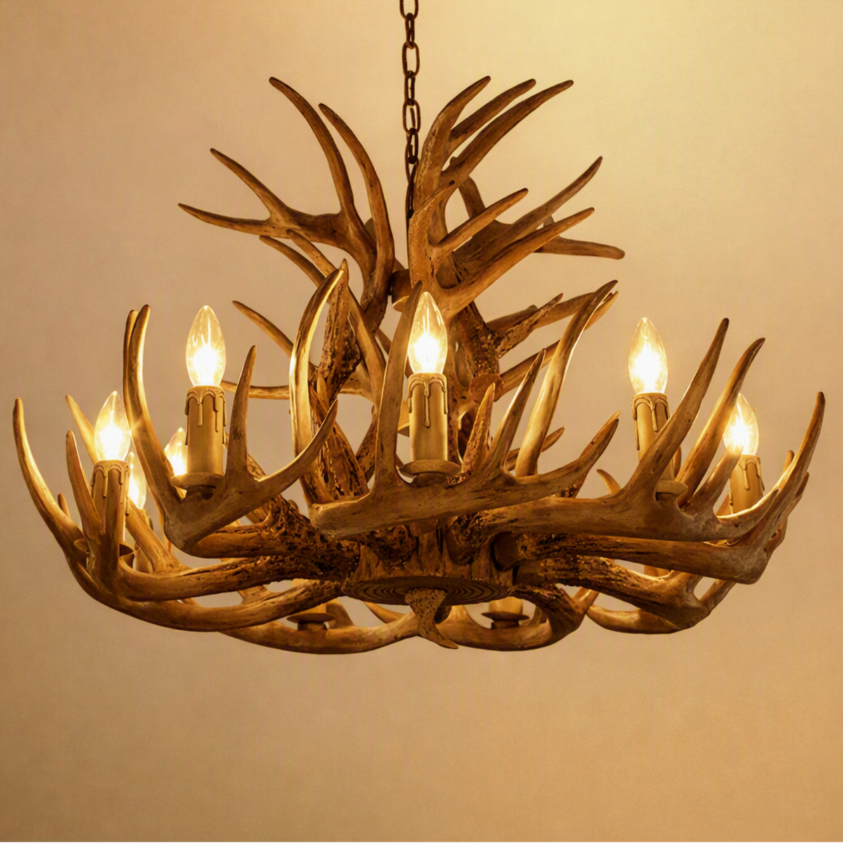 A rustic antler chandelier with multiple candle-style lights glowing warmly, suspended from a chain against a plain beige wall. A small 'Made with AI' badge appears in the top-right corner.