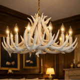A large multi-arm chandelier designed to look like white antlers, hanging in a dark wood-paneled room with lit bulbs turned on. A 'Made with AI' badge is visible in the top right corner.