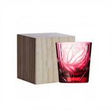 A pink cut-glass tumbler with a floral pattern, shown next to its light wood presentation box on a white background.