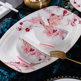 Floral teacup and saucer set on a decorative tablecloth with a fork.