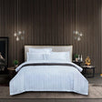 Modern bedroom with a bed, nightstands, and decorative items against a striped wall.
