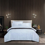 Modern bedroom with a bed, nightstands, and decorative items against a striped wall.