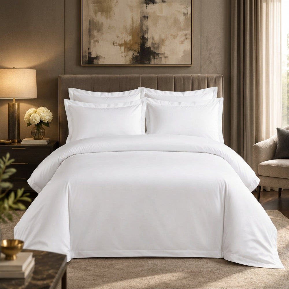 White bedding set on a bed in a bedroom with dark walls and decor.