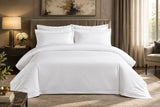 White bedding set on a bed in a bedroom with dark walls and decor.