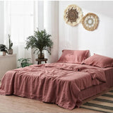Pink bedding set on a bed with decorative elements in a room.