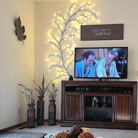 Living room with a TV, decorative plants, and wall art.