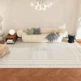 Living room with a beige sofa, patterned rug, and decorative pillows.