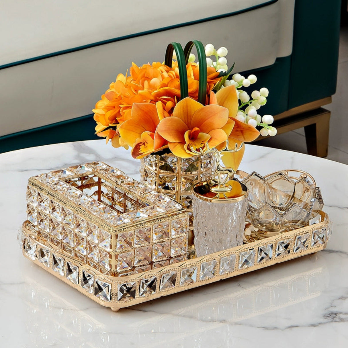 Decorative tray with crystal embellishments and a floral arrangement on a marble surface.