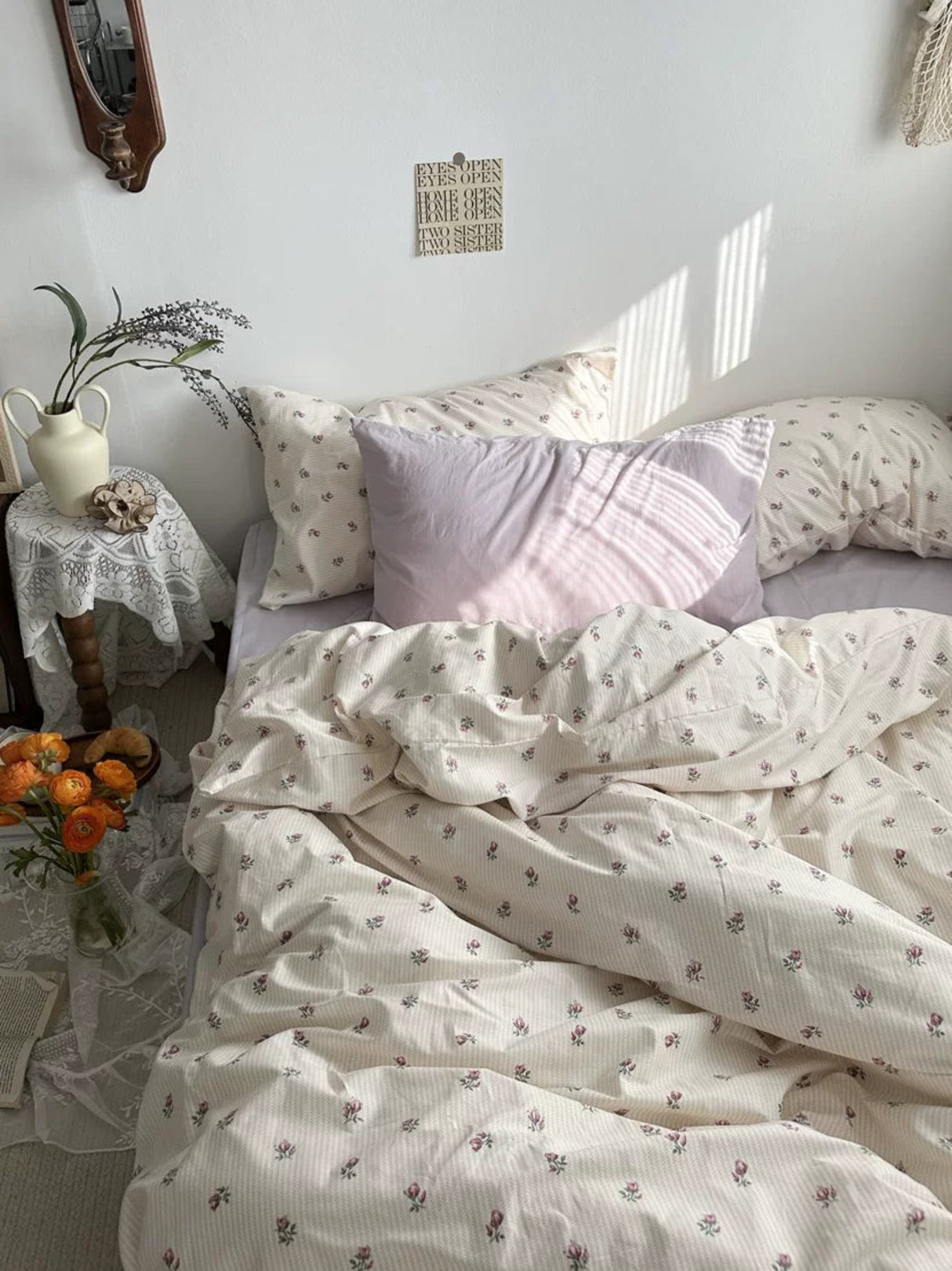 Bedroom with floral bedding and decorative pillows, sunlit room