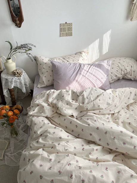 Bedroom with floral bedding and decorative pillows, sunlit room