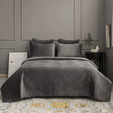 Gray quilt and pillows on a bed in a bedroom setting