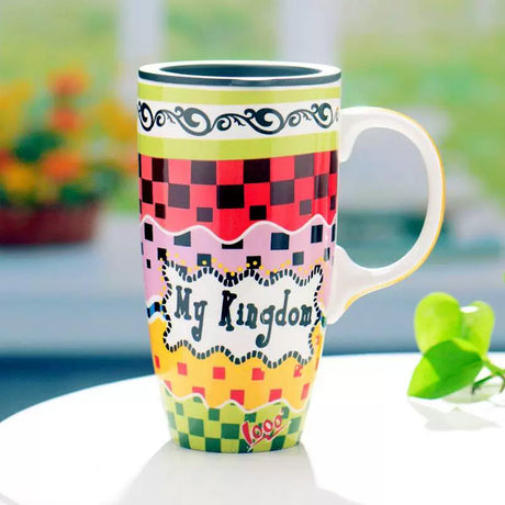 Colorful mug with 'My Kingdom' text on a blurred natural background