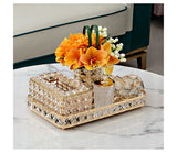 Decorative tray with crystal accents on a marble surface, featuring a small floral arrangement.