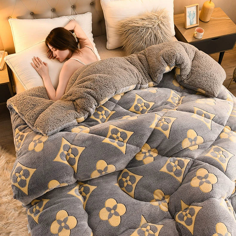 Woman lying on a bed with a patterned gray and yellow comforter