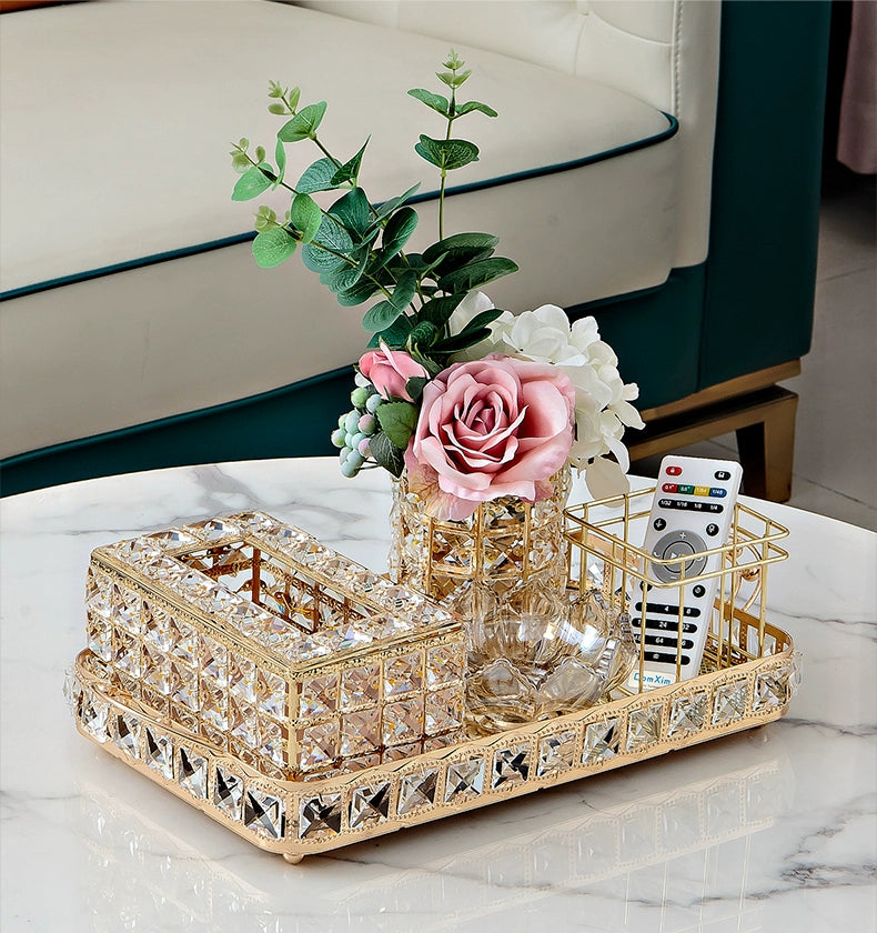 Decorative tray with flowers and remote controls on a marble surface