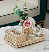 Decorative tray with flowers and remote controls on a marble surface