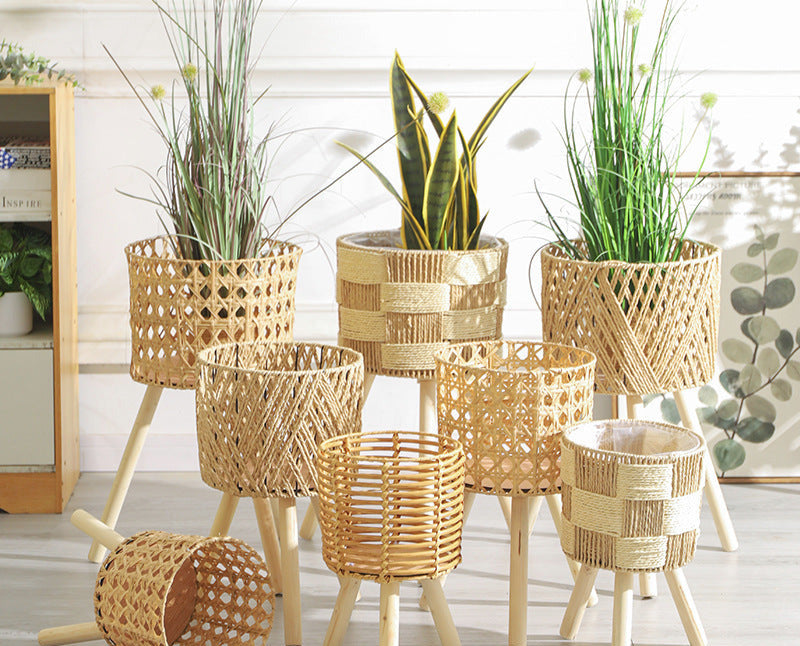 Wicker planters with plants on a light wooden floor