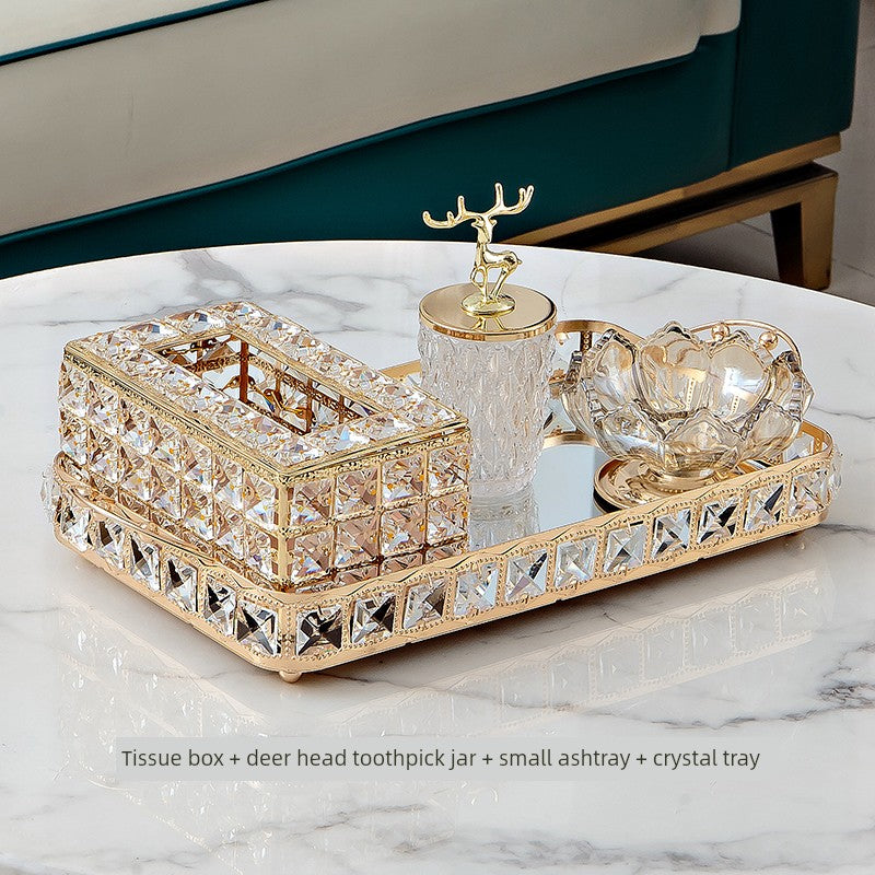 Decorative set with tissue box, deer head toothpick jar, small ashtray, and crystal tray on a marble surface.