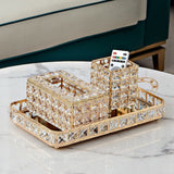 Decorative crystal tray with a cup and remote control on a marble surface.