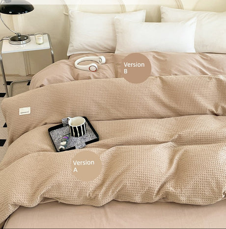 Beige comforter with 'AB double-sided design' on a bed in a bedroom setting.