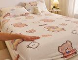 Bedding set with teddy bear design on a bed, featuring a hand touching the fabric.