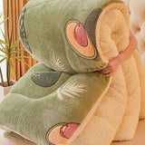 Avocado-shaped plush pillow held by a person in a home setting with plants.