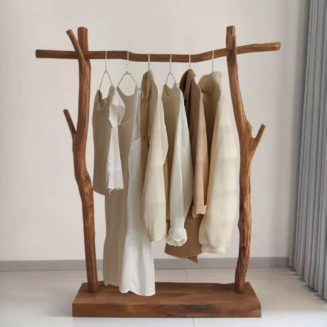 Wooden clothing rack with clothes on a neutral background