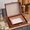 Open wooden jewelry box with decorative interior on a table.