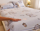 Bedding set with cartoon designs on a bed, featuring a hand touching the fabric.