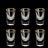 Set of six clear shot glasses with gold rims on a black background