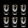 Set of six clear shot glasses with gold rims on a black background