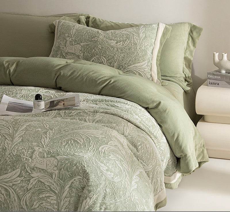 Green patterned bedding set on a bed with a side table in the background.