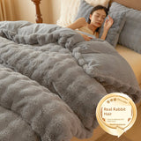 Person lying in bed under a fluffy gray comforter with a label indicating 'Real Rabbit Hair'.