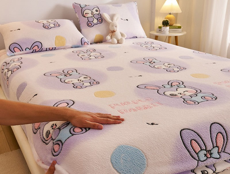 Bedding set with cartoon design on a bed, featuring a hand touching the fabric.