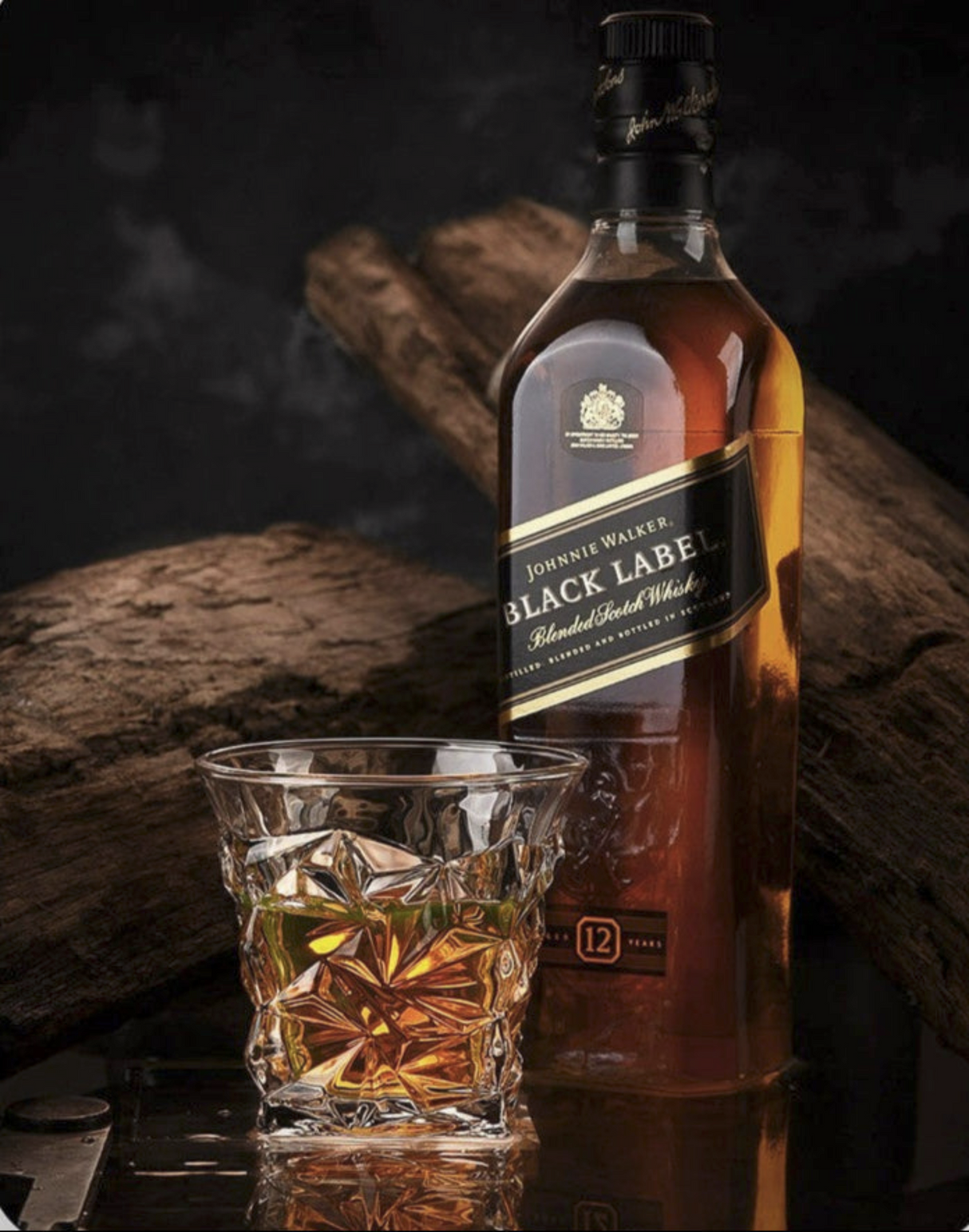 Johnnie Walker Black Label whiskey bottle with a glass of whiskey on a wooden surface.