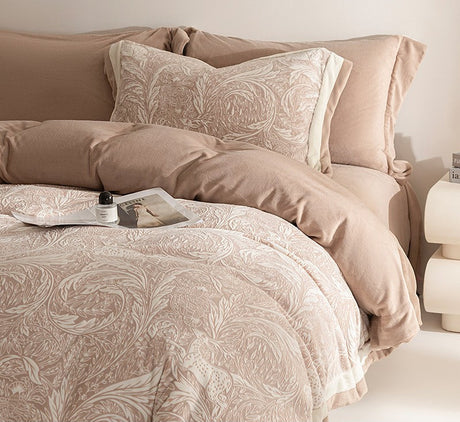 Neatly made bed with patterned bedding and pillows in a bedroom setting.