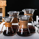 Set of four wooden and glass coffee brewing devices on a dark background