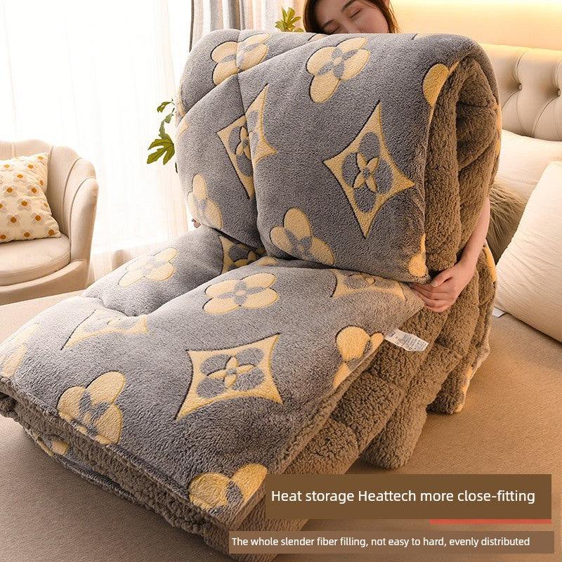 Person holding a large gray and brown patterned blanket in a living room.