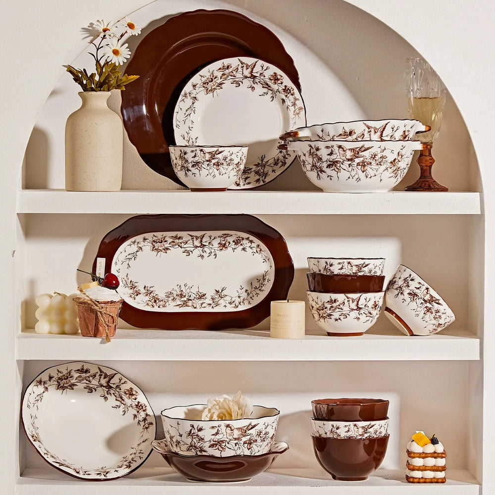 Set of ceramic dinnerware with floral patterns on a white shelf.