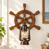 A rustic nautical wall sconce featuring a dark brown wooden ship's wheel with a hanging vintage-style lantern below it, shown against a plain light gray wall. The text 'Turn off the lights' appears in the upper left corner.